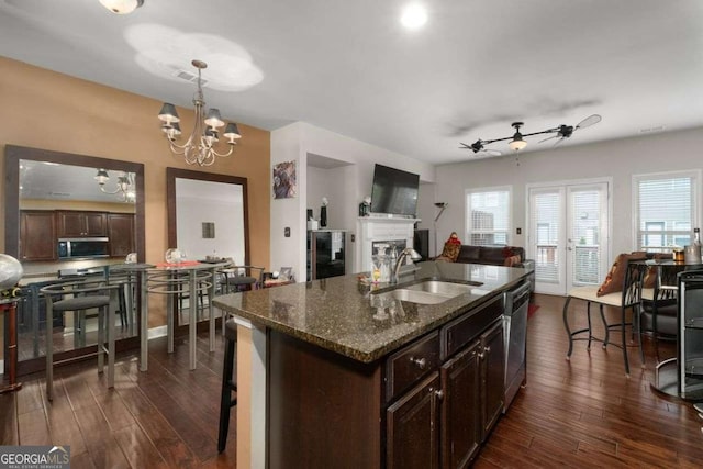 kitchen featuring a sink, stainless steel appliances, dark wood-type flooring, and open floor plan