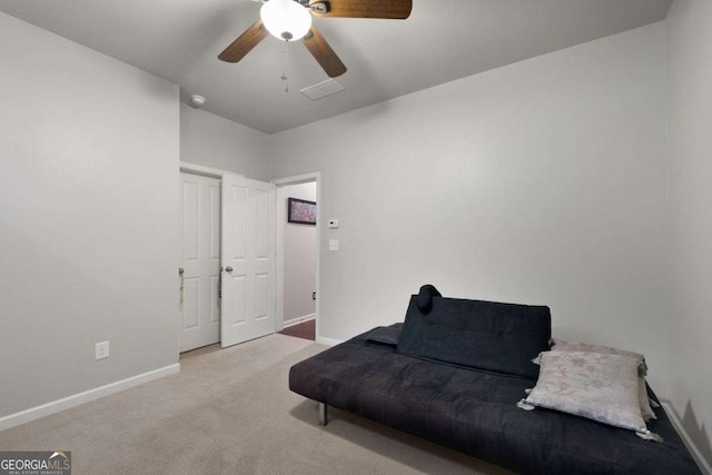sitting room featuring baseboards, ceiling fan, and carpet flooring