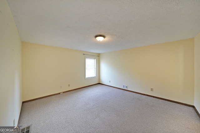 carpeted spare room with baseboards and a textured ceiling