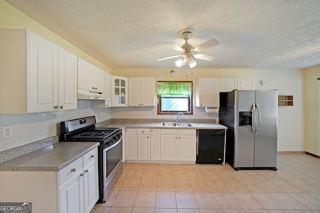 kitchen featuring stainless steel appliances, a sink, under cabinet range hood, tasteful backsplash, and a textured ceiling