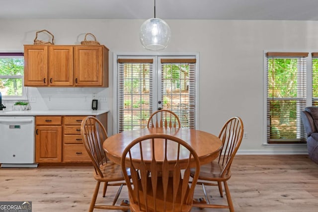 dining area with light wood-style floors, healthy amount of natural light, and baseboards
