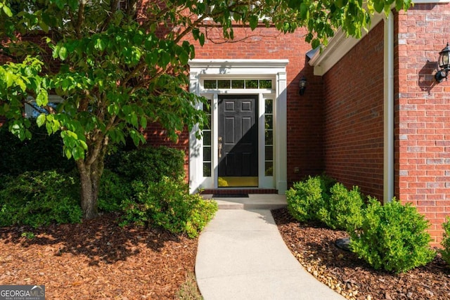 view of exterior entry with brick siding