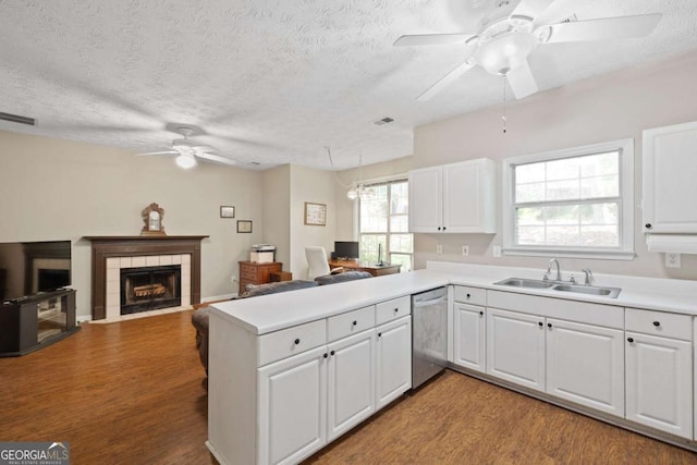 kitchen with a sink, a ceiling fan, dishwasher, a peninsula, and light wood-style flooring