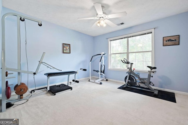 workout room featuring a ceiling fan, carpet, a textured ceiling, and baseboards