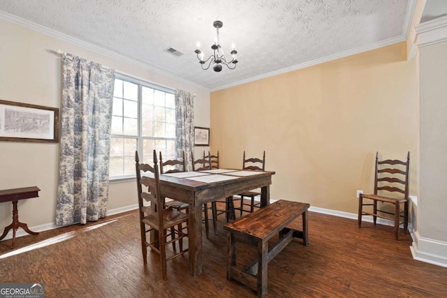 dining area featuring wood finished floors, a chandelier, a textured ceiling, baseboards, and ornamental molding