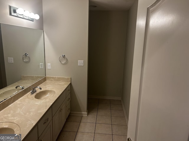 bathroom featuring tile patterned floors, double vanity, and baseboards