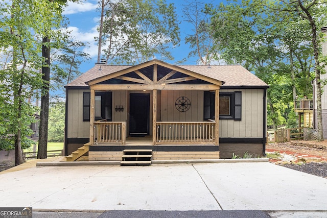 view of front of house with a shingled roof and a porch