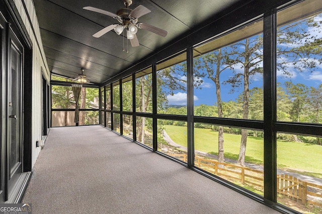unfurnished sunroom with ceiling fan, healthy amount of natural light, and lofted ceiling