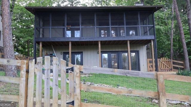 back of property featuring fence, a sunroom, french doors, a chimney, and a gate
