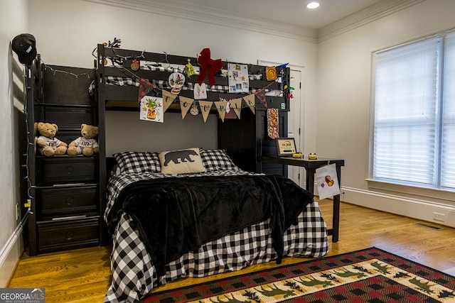 bedroom featuring crown molding, wood finished floors, and recessed lighting