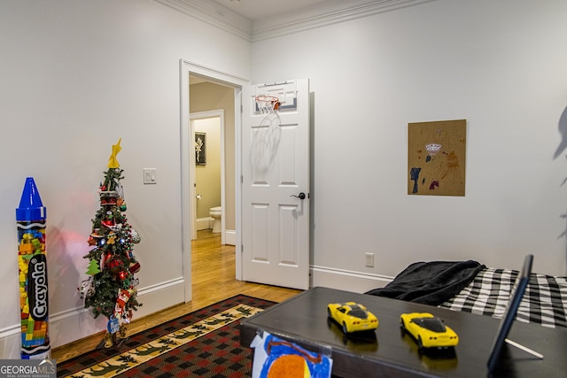 living room featuring wood finished floors, crown molding, and baseboards