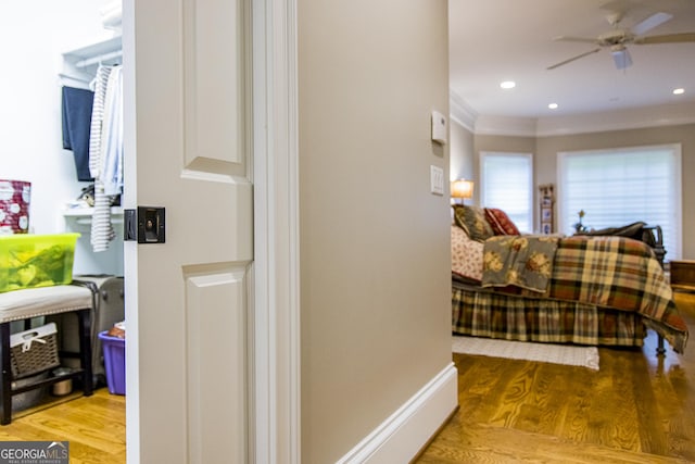 hall featuring wood finished floors, ornamental molding, and recessed lighting