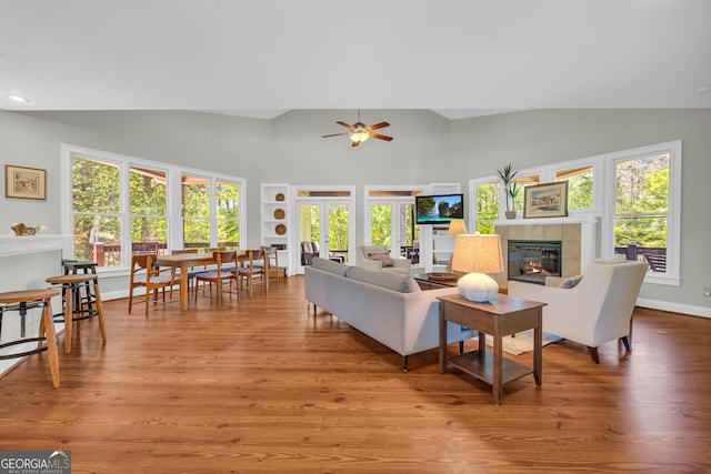 living area featuring a fireplace, ceiling fan, wood finished floors, high vaulted ceiling, and recessed lighting