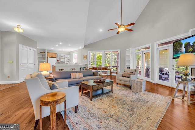 living area featuring ceiling fan, built in features, french doors, wood finished floors, and recessed lighting