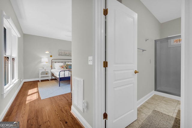 hallway with baseboards, healthy amount of natural light, and wood finished floors