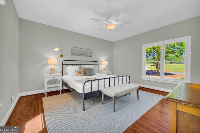 bedroom with baseboards, wood finished floors, and a ceiling fan