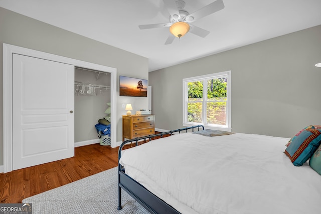 bedroom with wood finished floors, a closet, baseboards, and a ceiling fan