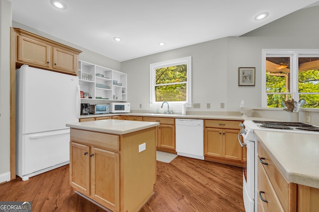 kitchen featuring white appliances, a sink, light wood-style flooring, light brown cabinets, and light countertops