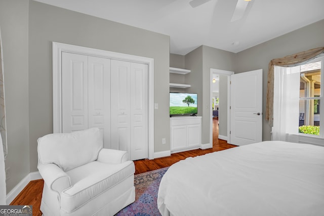 bedroom featuring wood finished floors, a closet, baseboards, and a ceiling fan