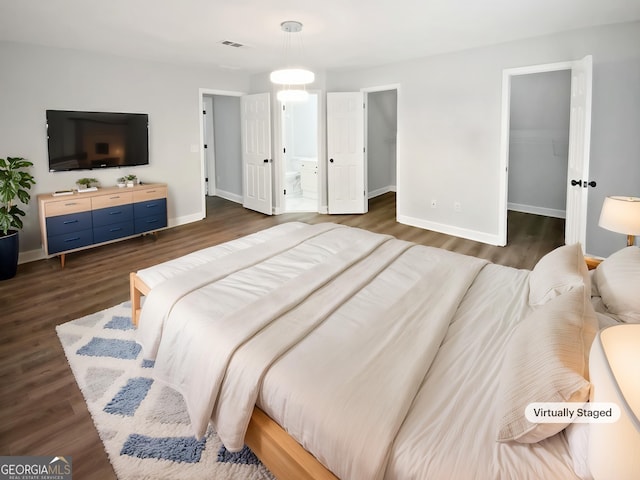 4345 Park Brooke Trce, Johns Creek, GA 30022 - bedroom featuring a spacious closet, dark wood-type flooring, and ensuite bath