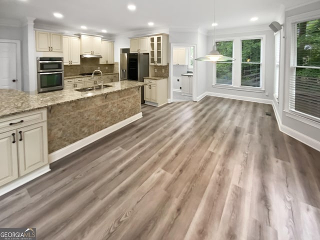 4345 Park Brooke Trce, Johns Creek, GA 30022 - kitchen with ornamental molding, cream cabinetry, under cabinet range hood, plenty of natural light, and recessed lighting