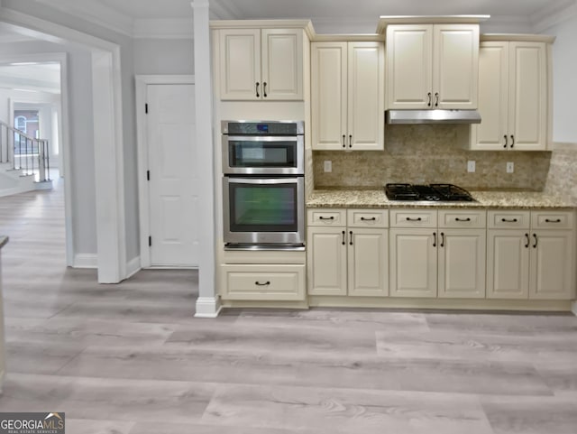 4345 Park Brooke Trce, Johns Creek, GA 30022 - kitchen with black gas cooktop, crown molding, double oven, under cabinet range hood, and cream cabinets