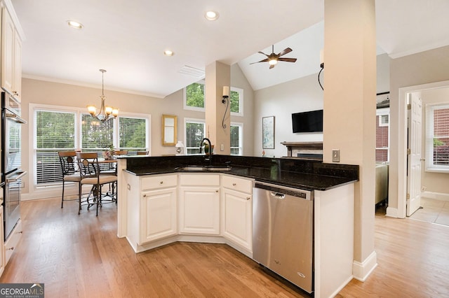 1640 Settindown Dr, Roswell, GA 30075 - kitchen featuring appliances with stainless steel finishes, a sink, light wood finished floors, white cabinetry, and vaulted ceiling