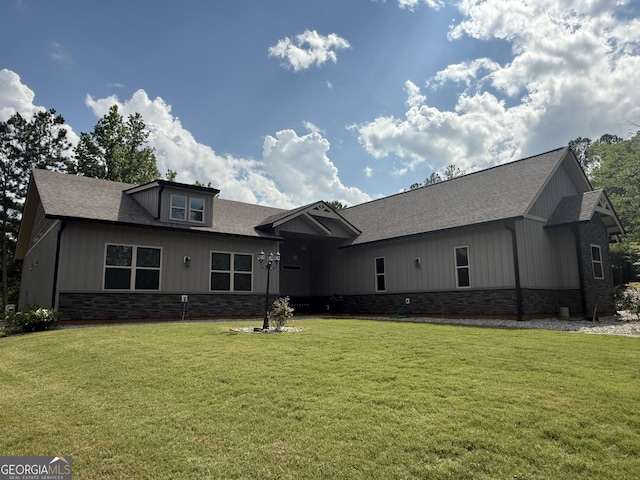 rear view of property with a yard and a shingled roof