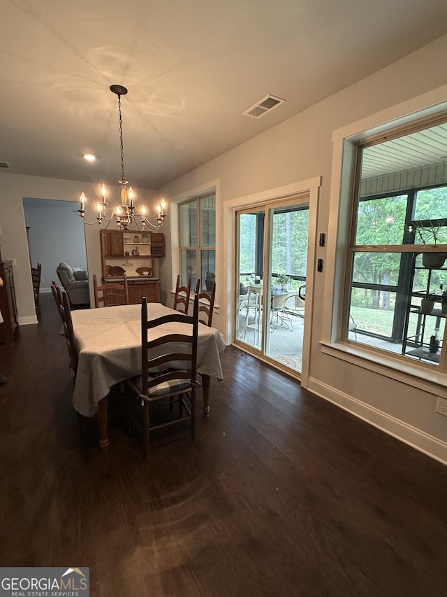 dining area featuring a chandelier, baseboards, and dark wood-style flooring