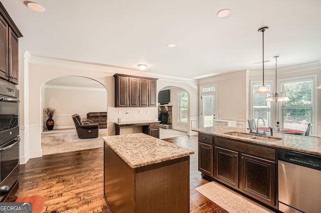 349 Pennant Ln, Fairburn, GA 30213 - kitchen featuring appliances with stainless steel finishes, arched walkways, a sink, crown molding, and dark brown cabinets