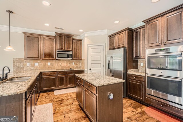 349 Pennant Ln, Fairburn, GA 30213 - kitchen with a sink, appliances with stainless steel finishes, ornamental molding, light stone countertops, and decorative light fixtures