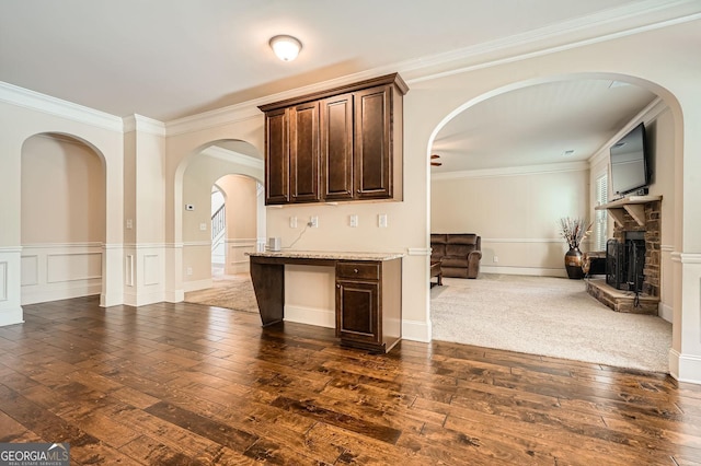 349 Pennant Ln, Fairburn, GA 30213 - unfurnished living room with ornamental molding, dark wood-style flooring, a stone fireplace, and arched walkways