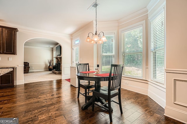 349 Pennant Ln, Fairburn, GA 30213 - dining space featuring arched walkways, a decorative wall, dark wood-type flooring, ornamental molding, and a wainscoted wall