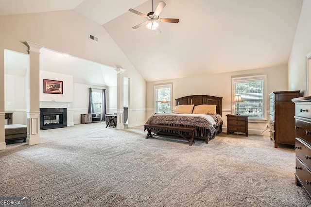 349 Pennant Ln, Fairburn, GA 30213 - bedroom featuring decorative columns, carpet flooring, high vaulted ceiling, a glass covered fireplace, and a ceiling fan