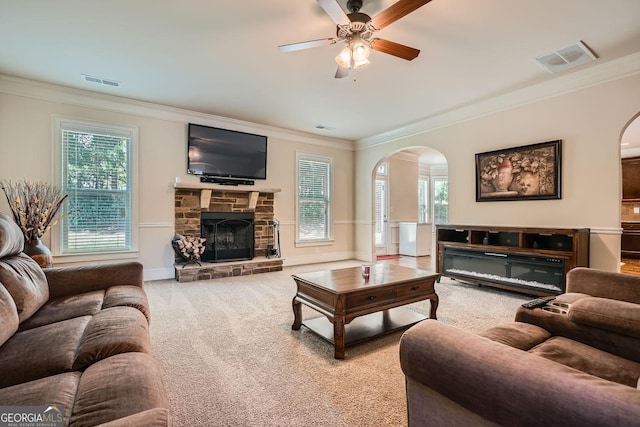 349 Pennant Ln, Fairburn, GA 30213 - living room featuring arched walkways, crown molding, a ceiling fan, carpet, and a stone fireplace