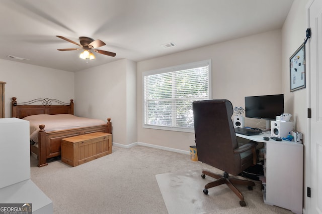 bedroom featuring light colored carpet, a ceiling fan, a desk, and baseboards