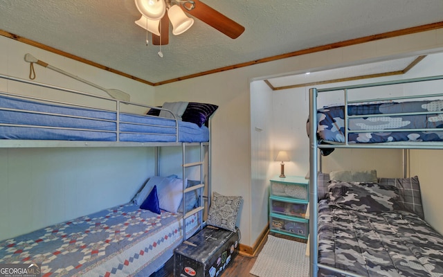 bedroom with wood finished floors, ornamental molding, a textured ceiling, and ceiling fan