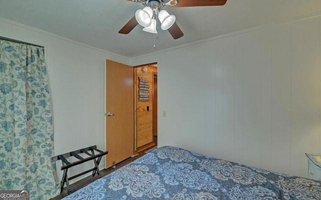 bedroom with crown molding, a ceiling fan, and wood finished floors