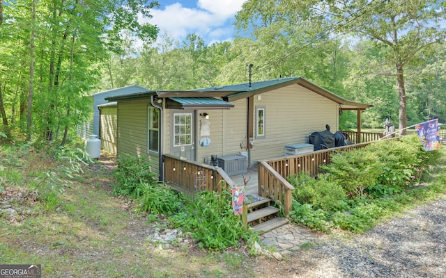 back of property with a deck and metal roof