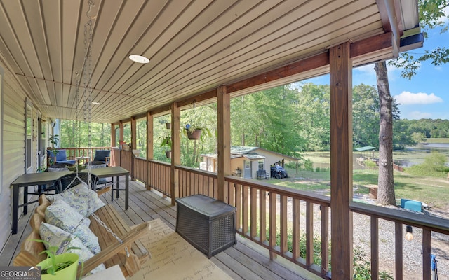 wooden deck featuring a water view and view of scattered trees