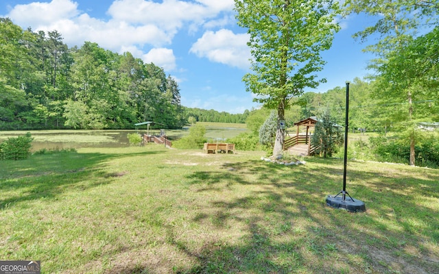 view of grassy yard with a view of trees and a gazebo