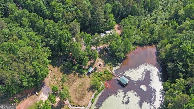 aerial view of property's location with a nearby body of water and a forest