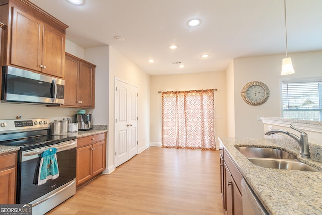 7155 Pine Seed Dr, Midland, GA 31820 - kitchen with appliances with stainless steel finishes, a sink, brown cabinets, light wood finished floors, and recessed lighting