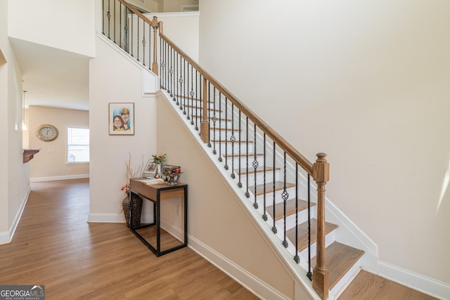 7155 Pine Seed Dr, Midland, GA 31820 - stairs featuring wood finished floors, baseboards, and a high ceiling