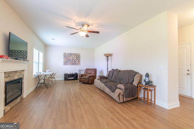 7155 Pine Seed Dr, Midland, GA 31820 - living area featuring light wood-type flooring, a ceiling fan, a stone fireplace, and baseboards