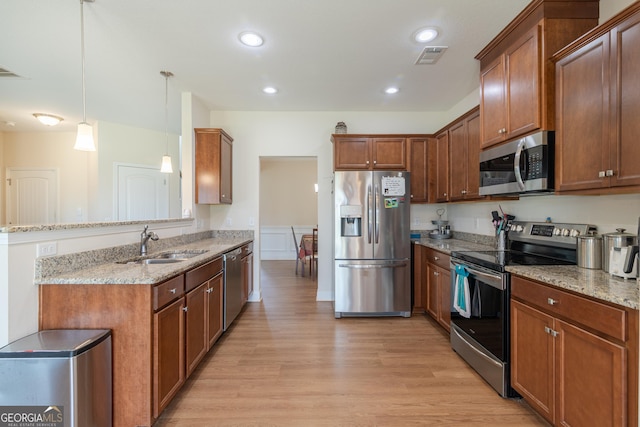7155 Pine Seed Dr, Midland, GA 31820 - kitchen with stainless steel appliances, a sink, light wood-type flooring, a peninsula, and light stone countertops