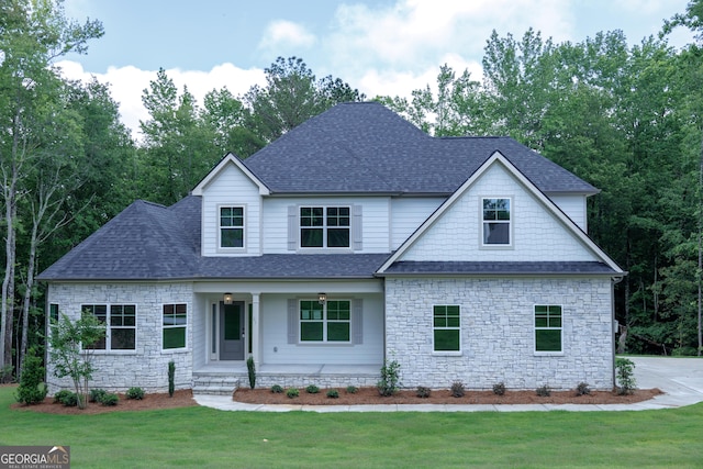 214 Wet Wood Ct Unit 26, Fairburn, GA 30213 - view of front facade with covered porch, stone siding, a front lawn, and roof with shingles