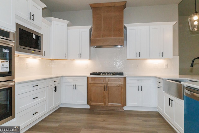 214 Wet Wood Ct Unit 26, Fairburn, GA 30213 - kitchen featuring stainless steel appliances, a sink, premium range hood, decorative backsplash, and light countertops
