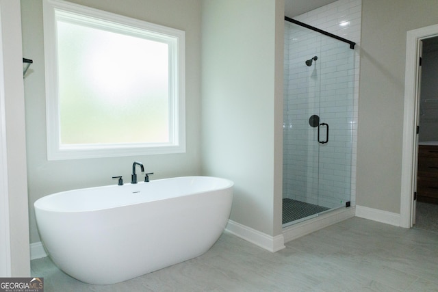 214 Wet Wood Ct Unit 26, Fairburn, GA 30213 - bathroom featuring a stall shower, a freestanding tub, and baseboards