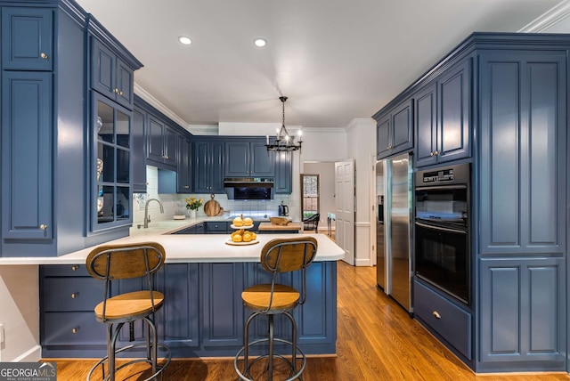 130 River Lndg NE, Sandy Springs, GA 30350 - kitchen featuring stainless steel fridge with ice dispenser, multiple ovens, a peninsula, blue cabinetry, and light countertops